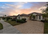 One-story home with a tile roof, and a large driveway at 2763 Phoenix Palm Ter, North Port, FL 34288