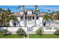 Two-story home with metal roof, gated entry, and artistic wall decor at 345 Madison Dr, Sarasota, FL 34236