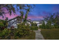 Two-story house with landscaped yard, stone accents, and a walkway at 3651 Country Place Blvd, Sarasota, FL 34233