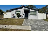 Charming house with gray exterior, paver driveway, and landscaped lawn at 4029 9Th S Ave, St Petersburg, FL 33711