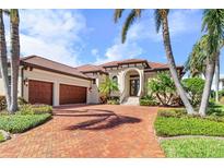 Luxury home with three-car garage, brick driveway, and lush landscaping at 4110 Commodore Blvd, Cortez, FL 34215