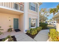 Inviting condo entry with a teal door and well-manicured landscaping at 4705 Sand Trap Street E Cir # 106, Bradenton, FL 34203