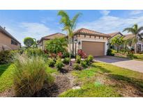 Single-story home with a landscaped yard and attached garage at 5337 Popoli Way, Sarasota, FL 34238