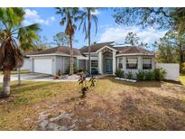 Gray house with teal front door, white pergola, and landscaped yard at 5574 Sweetwater Oak, Sarasota, FL 34232