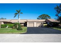 Tan colored exterior of a two-story home with a two car garage and manicured lawn at 5640 Westwind Ln, Sarasota, FL 34231