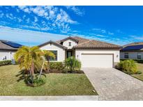 Single-story home with tile roof, two-car garage, and lush landscaping at 6534 Clairborne Ln, Lakewood Ranch, FL 34211