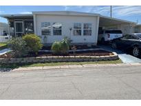 Well-maintained manufactured home with carport and landscaped yard at 712 51St Avenue W Ter, Bradenton, FL 34207