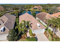 Aerial view of single-Gathering home with tile roof, landscaping, and driveway at 7121 Orchid Island Pl, Bradenton, FL 34202