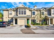 Tan two-story townhome with green door, two-car garage, and landscaping at 7560 Plantation Cir, Bradenton, FL 34201