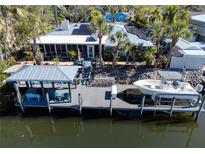 Waterfront backyard featuring a private boat dock, boat lift, and tropical landscaping at 903 20Th W Ave, Palmetto, FL 34221