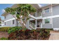 Gray condo building with stairs leading to entrance and landscaping at 1341 Perico Point Cir # 116, Bradenton, FL 34209