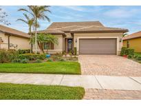 Single-story home with brown garage door and landscaped front yard at 13925 Miranese St, Venice, FL 34293