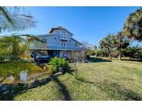 Elevated home with water access, lush landscaping, and ample parking at 145 Burns Rd, Terra Ceia, FL 34250