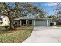 Single-story house with green exterior, attached garage, and landscaping at 14802 7Th E Ave, Bradenton, FL 34212