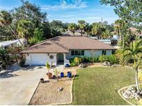 Aerial view of a single-story house with a well-maintained lawn and driveway at 180 Aurora Rd, Venice, FL 34293