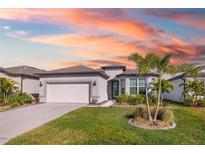 White one-story house with a two-car garage and palm trees in front at 2930 61St E Dr, Ellenton, FL 34222