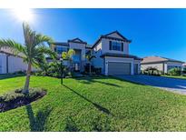 Two-story house with gray siding, landscaping, and a three-car garage at 4852 Coastal Days Ln, Bradenton, FL 34211