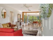 Bright living room with mid century modern furniture and hardwood floors at 603 Barnes Pkwy, Nokomis, FL 34275