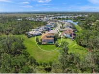 Aerial view of a house and surrounding community with a large backyard at 6229 Rivo Lakes Blvd, Sarasota, FL 34241