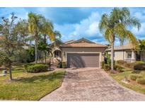 Single-story home with a two-car garage and landscaped yard at 6730 Haverhill Ct, Bradenton, FL 34202