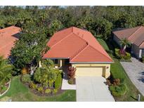 Attractive single-story home with a red tile roof, well-manicured landscaping, and a two-car garage at 735 Foggy Morn Ln, Bradenton, FL 34212