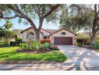 Single-story home with mature landscaping and a two-car garage at 804 Connemara Cir, Venice, FL 34292