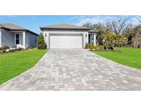 New home exterior with paver driveway and landscaping at 9405 Ballaster Pointe Loop, Parrish, FL 34219