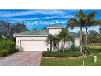 Beautiful one-story home with lush landscaping and a brick driveway at 11458 Saffron Ct, Venice, FL 34292