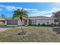 Single-story home with a palm tree and a screened-in porch at 2551 Morrietta Ln, North Port, FL 34286