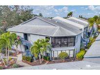 Two-story condo building with screened balconies, lush landscaping, and stairs at 2728 71St Street W Ct # 2078, Bradenton, FL 34209