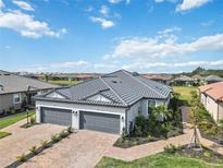 Two-car garage, paver driveway, and tile roof with a beautiful backyard view at 3016 Formia Ct, Bradenton, FL 34211