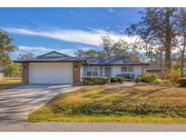 White single-story house with attached garage and landscaped yard at 3762 San Luis Dr, Sarasota, FL 34235