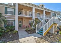 Charming condo with white railings, stairs and nicely landscaped garden beds in a well-maintained community at 4705 Sand Trap Street E Cir # 105, Bradenton, FL 34203