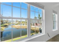 Bright room with large windows offering serene views of the community pond and pool area at 5711 Soldier Cir # 204, Sarasota, FL 34233