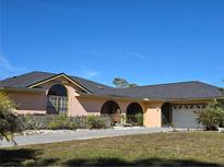 Single-story house with a large driveway and a two-car garage at 7020 Sena Rd, North Port, FL 34291