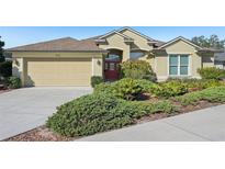 House exterior featuring a two-car garage and well-manicured landscaping at 7302 Deer Crossing Ct, Sarasota, FL 34240