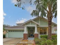 Charming single-Gathering home featuring a well-manicured lawn and inviting curb appeal with mature palm trees at 8030 Hampton Lake Dr, Tampa, FL 33647