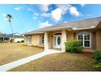 House exterior featuring a tan-colored house with a walkway leading to the front door at 13609 2Nd Ne Ave, Bradenton, FL 34212