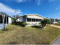 Single-wide manufactured home with carport and landscaped lawn at 308 Danube Cir, Bradenton, FL 34207