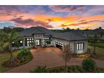 Luxury home with tile roof, stone accents, and a 3-car garage at 3123 Founders Club Dr, Sarasota, FL 34240