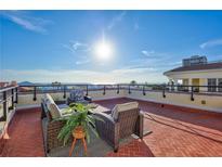 Spacious rooftop terrace with ocean views, wicker furniture, and brick paving at 317 Beach Rd, Sarasota, FL 34242