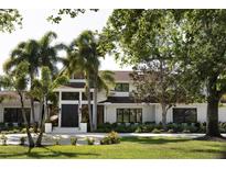 Stunning white two-story home with palm trees and manicured lawn at 3709 Beneva Oaks Way, Sarasota, FL 34238