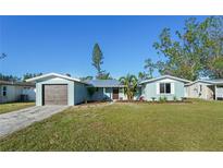 Charming single-story home with a well-manicured lawn, blue paint, and a detached garage at 3952 Coleridge Pl, Sarasota, FL 34241