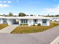 Charming single-story home with a well-manicured lawn, blue trim, and a white roof at 477 Circlewood Dr # O-17, Venice, FL 34293