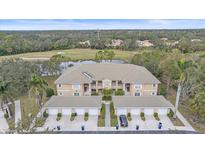 Aerial view of condo community showcasing building, landscaping, and golf course views at 6334 Grand Oak Cir # 201, Bradenton, FL 34203