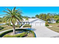 White two-story house with a three-car garage and palm trees at 6851 Country Lakes Cir, Sarasota, FL 34243