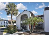 Attractive condo building with palm trees and walkway at 796 Capri Isles Blvd # 241, Venice, FL 34292