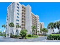 Exterior view of a multi-story building with lush landscaping at 9393 Midnight Pass Rd # 302, Sarasota, FL 34242