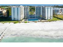 Aerial view of a beachfront condo building with a pool and beach access at 2295 Gulf Of Mexico Dr # 115S, Longboat Key, FL 34228