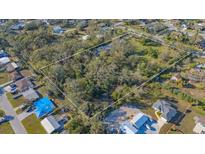 A spacious lot with mature trees, outlined in white, offering privacy and potential for building at 3864 Gocio Rd, Sarasota, FL 34235